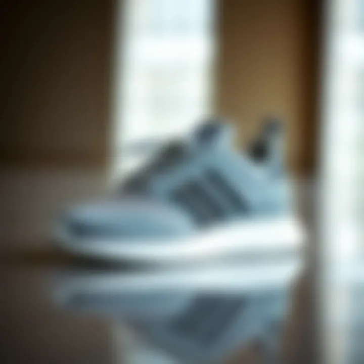 Stylish grey adidas Astir sneakers on a reflective surface