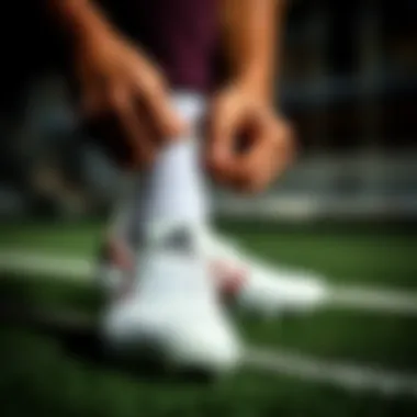 A player lacing up Adidas leather cleats, emphasizing comfort and fit